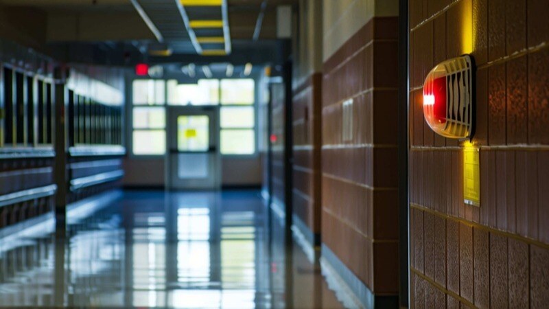 Featured image: fire alarm in school hallway -  Avoiding School Funding Summertime Blues: How to Budget for Fire Safety System Maintenance